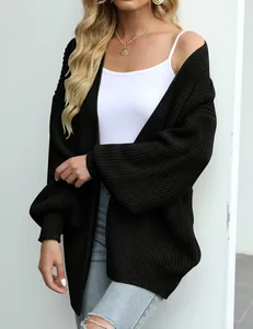 Detailopname van zwart grofgebreid vest met lantaarnmouwen voor de herfst- en wintermode.