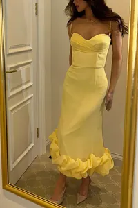 Full view of elegant yellow spaghetti strap dress with structural ruffled hem detail