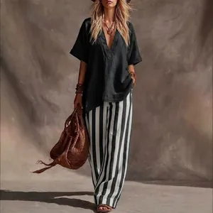 Loose black V-neck top and striped wide-leg pants fashion two-piece set for women.