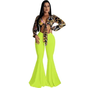 Detail view of sexy neon green high-waisted flare pants with a slim fit ruffle hem