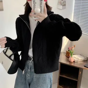 Cozy black cable knit cardigan with double zipper and high neck shown in lifestyle setting