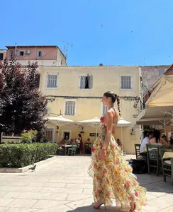 Floral organza maxi dress featuring tiered ruffles and an elegant backless design in a plaza.