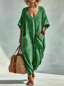 Full-body view of a relaxed-fit green linen jumpsuit with deep V-neck and pockets
