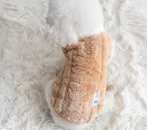 Detailed view of soft brown fleece dog vest with a leash D-ring on a cozy white rug