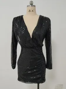 Detail view of a black sequined V-neck dress with long sleeves and elegant ruching.
