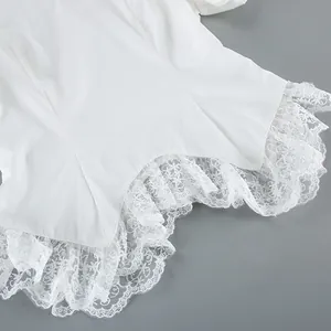 Detailopname van de fijne witte kantafwerking op een elegante shirt met pofmouwen