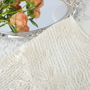 Primo piano della delicata trama del tessuto in pizzo jacquard bianco con fiori.