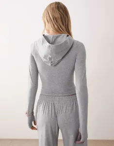 Vista posteriore set felpa grigia con cappuccio e pantaloni jogger con fori per il pollice