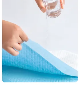 Detail showing water pouring into a thick blue pet training pad for high absorbency.