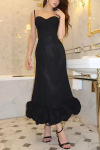 Elegant black slim-fit camisole midi dress with ruffled hem in luxury bathroom setting