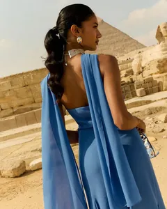 Gros plan d'une élégante robe en mousseline bleue avec rubans devant les pyramides.