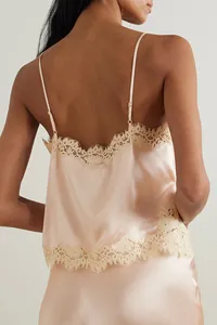 Close-up detail showing the back of a pink satin camisole with elegant cream eyelash lace trim