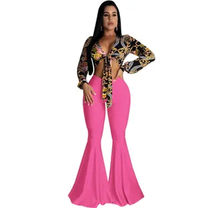 Sexy two-piece set featuring a patterned crop top and pink flare bell-bottom trousers.