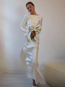 Close-up of elegant white satin dress with long bell sleeves and high side slit