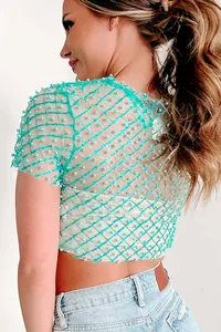 Close-up detail of a sexy turquoise mesh short sleeve top with elegant pearl beads