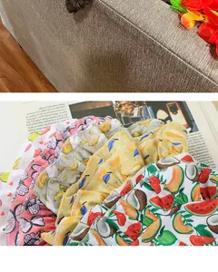 Close-up of colorful fruit and butterfly patterned pet dresses with ruffled edges