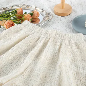 Dettaglio degli shorts in pizzo jacquard bianco con delicato motivo floreale ricamato