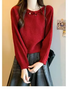 Detailed macro shot of a soft red knitted sweater with an elegant knotted neckline detail.