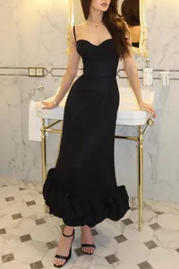Elegant black spaghetti strap evening dress featuring a unique ruffled hem and slim fit