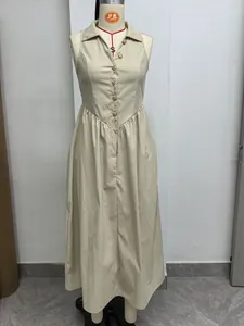 Volledig detail van een beige mouwloze lange jurk met reverskraag en gouden knopen