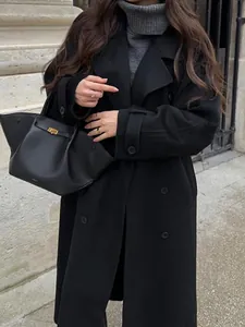 Detail shot of a black double-breasted long coat with classic lapels and buttons