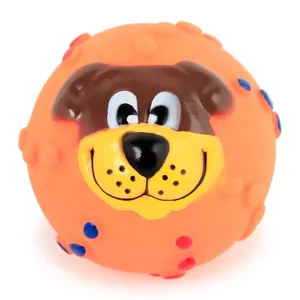 Macro view of textured orange squeaky dog toy ball with smiling cartoon dog face