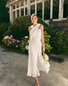 Robe élégante en mousseline blanche avec licou croisé dans un jardin