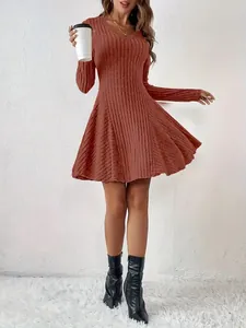 Detailed view of an elegant rust-colored knit V-neck long sleeve mini flared dress