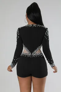 Vista posteriore dettagliata di una tutina nera con perle e strass luccicanti.