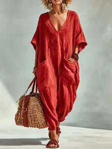 Full shot of a red V-neck cotton linen jumpsuit with large pockets for beach vacation.