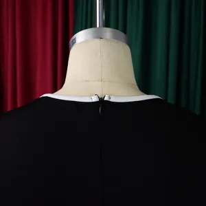 Detailed macro view showing the back hidden zipper and white trim on an elegant black dress