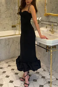 Elegant black slim-fit cami dress with ruffled hem in a luxury bathroom setting