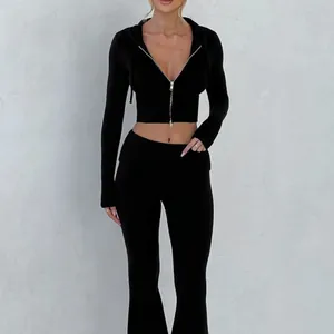 Completo due pezzi donna con felpa con cappuccio corta e pantaloni a zampa neri