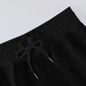 Close-up detail of high-waisted black wide-leg pants with elastic drawstring waist