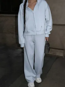 Model wearing a light blue 2-piece sports set with zip-up hoodie and trousers