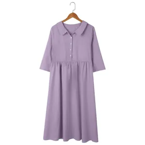 Close-up front view of a lavender cotton linen loose dress hanging on a wooden hanger