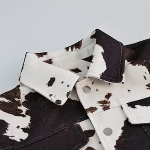 Detail van de kraag van het koeprint jack en zilveren metalen knopen voor stijl