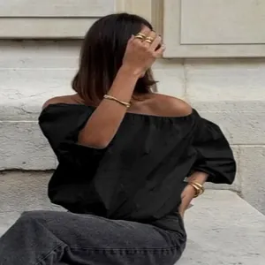 Elegant women's black off-the-shoulder puff sleeve top with a loose comfortable fit