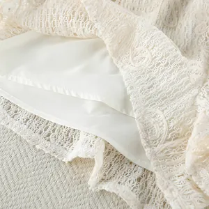 Vista dettagliata del tessuto in pizzo jacquard bianco sporco con fodera interna liscia