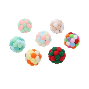 Set of seven colorful handmade plush cat toy balls for exercise and play on white background.