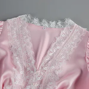 Close-up of white eyelash lace trim on a pink satin V-neck dress