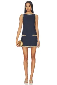 Detail of dark blue denim sleeveless dress with intricate rhinestone trim and pocket accents.