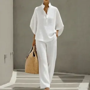 Élégant ensemble blanc gaufré avec chemise à boutons ample et pantalon à jambes larges.