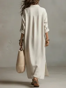 Back view detail of a loose off-white cotton linen shirt dress with side slits