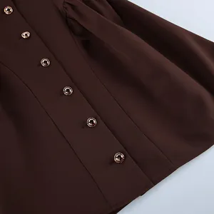 Close-up detail shot showing golden round buttons on retro brown sleeveless dress fabric