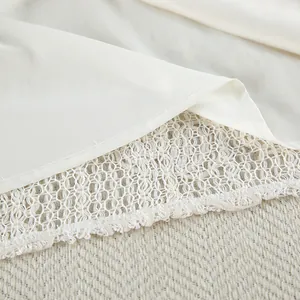 Dettaglio del tessuto jacquard bianco con bordo in pizzo all'uncinetto per set vacanze.