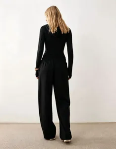 Vista posteriore dettagliata di felpa nera con cappuccio e pantaloni larghi casual