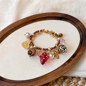 Gros plan d'un bracelet fraise avec perles et détail de nœud doré élégant