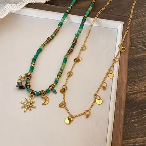 Dettaglio di una collana vintage con perline turchesi e ciondoli a stella dorati
