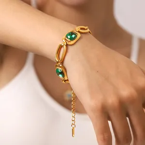 Close-up of a gold-toned titanium steel bracelet with square green zircon stones.